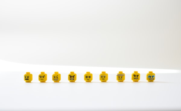 several frowning and angry yellow Lego™ heads against a white background