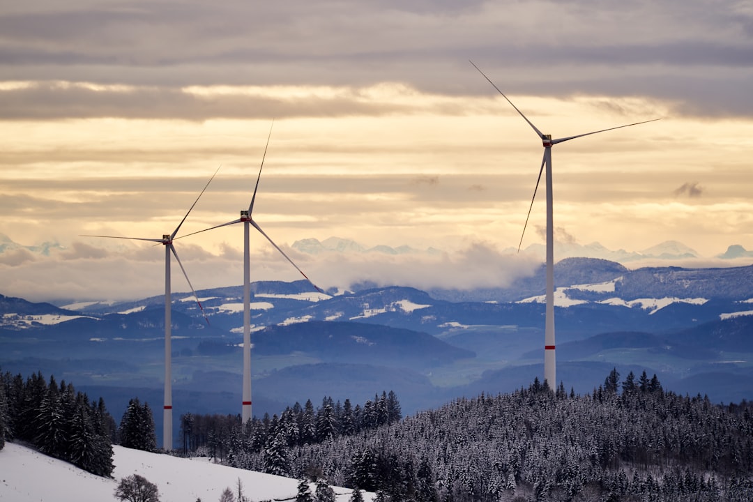 black wind turbines on snow covered mountain during daytime