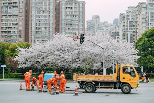A construction team marking street lines and planning road layouts in an urban area.