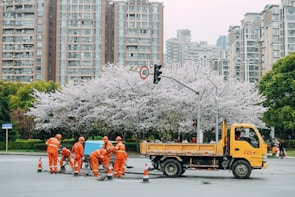 Orange-clad traffic controllers working together to manage roadwork in a Dutch city street.