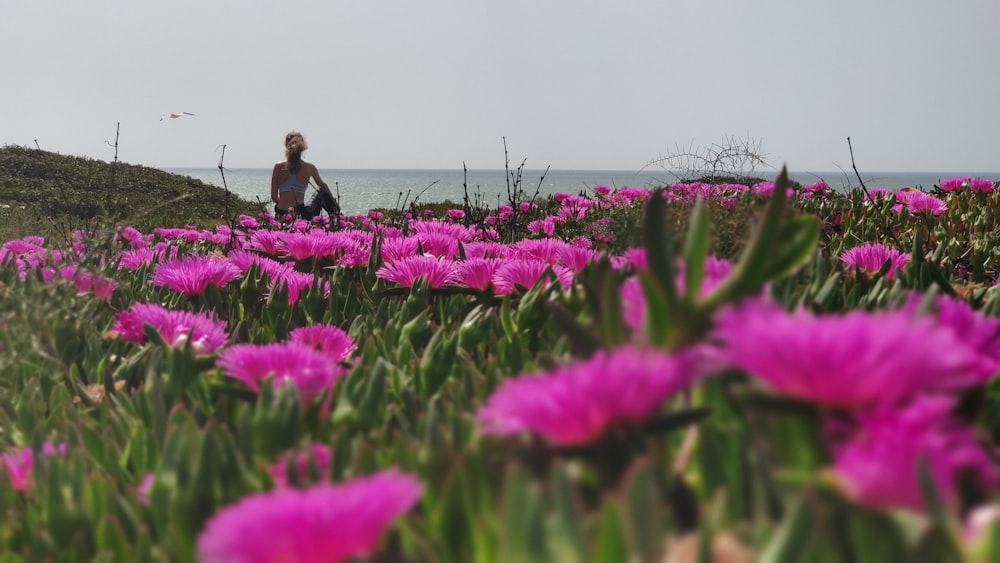 man in black jacket sitting on green grass field