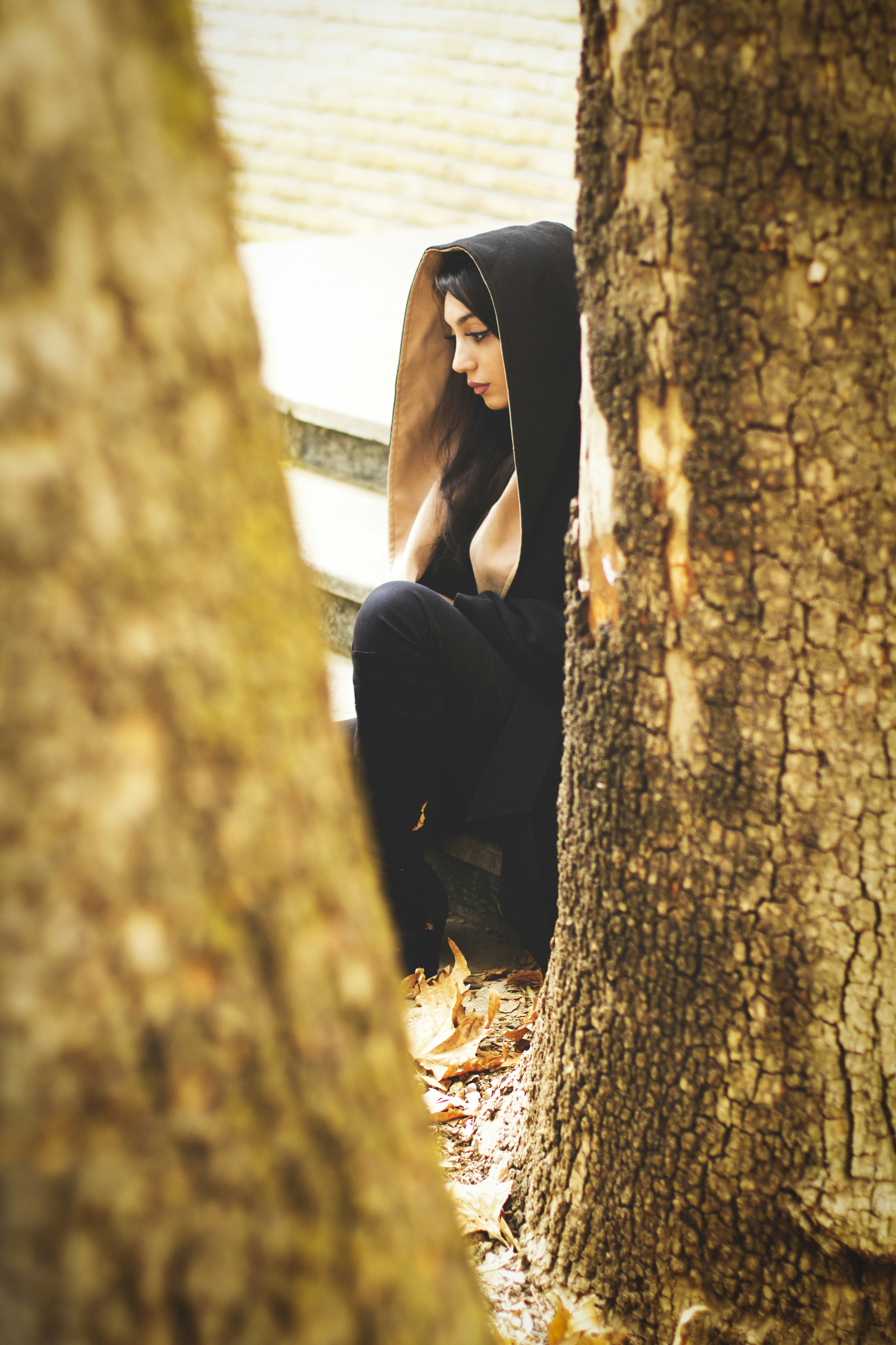 man in black suit sitting on tree trunk