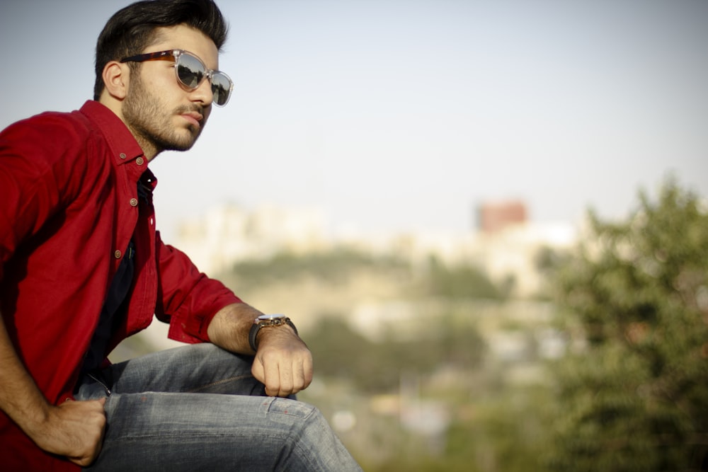 man in red jacket wearing black sunglasses