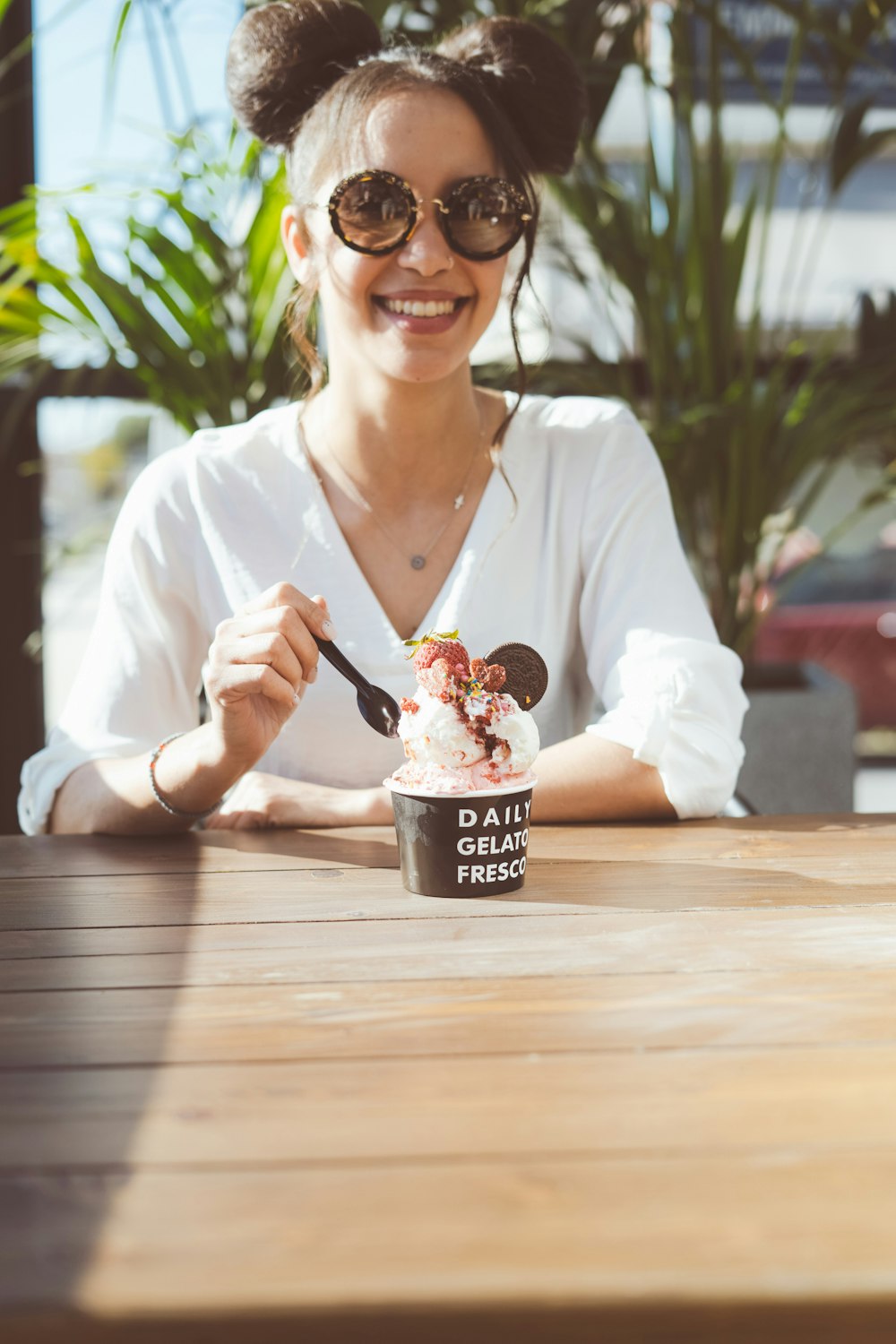 woman in white long sleeve shirt holding cup of ice cream