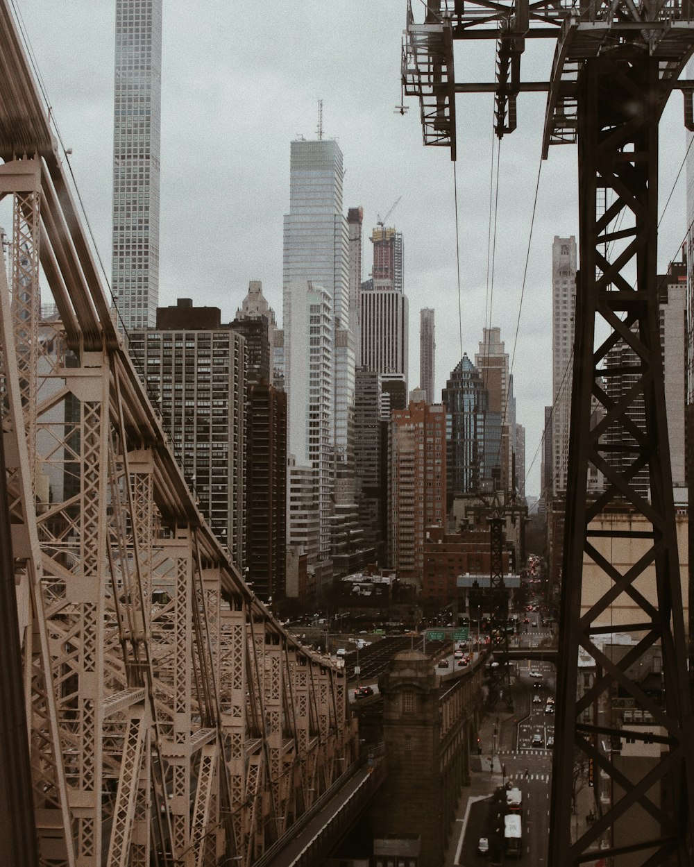 cars on bridge near high rise buildings during daytime