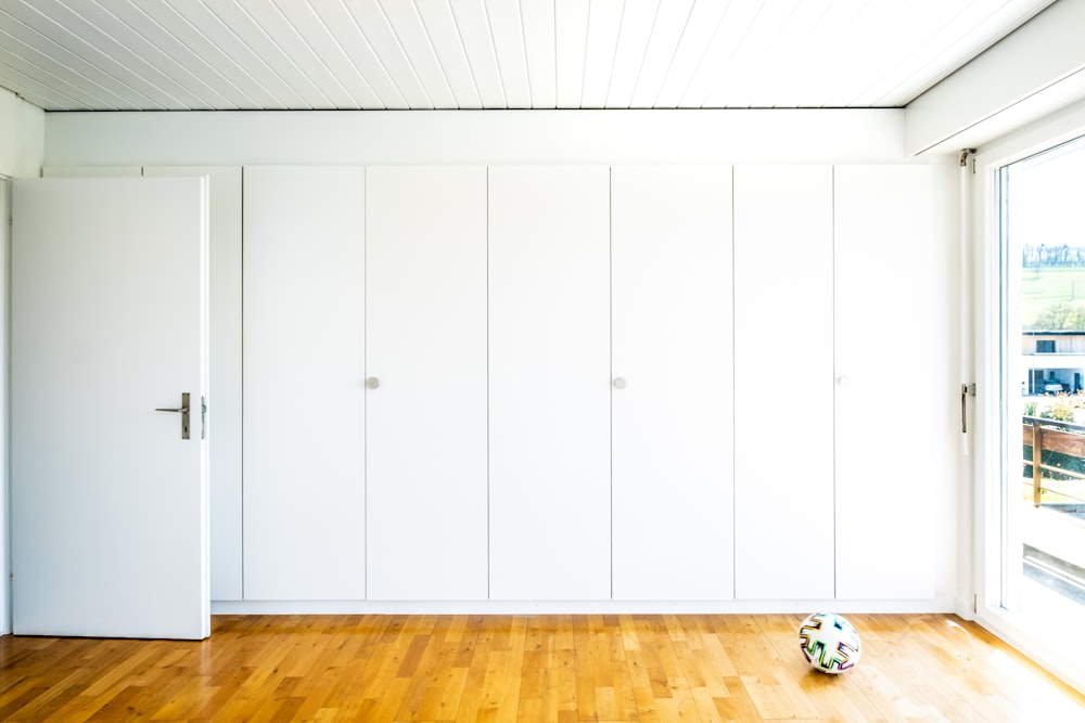 Coche de juguete blanco y rojo sobre suelo de parquet de madera marrón