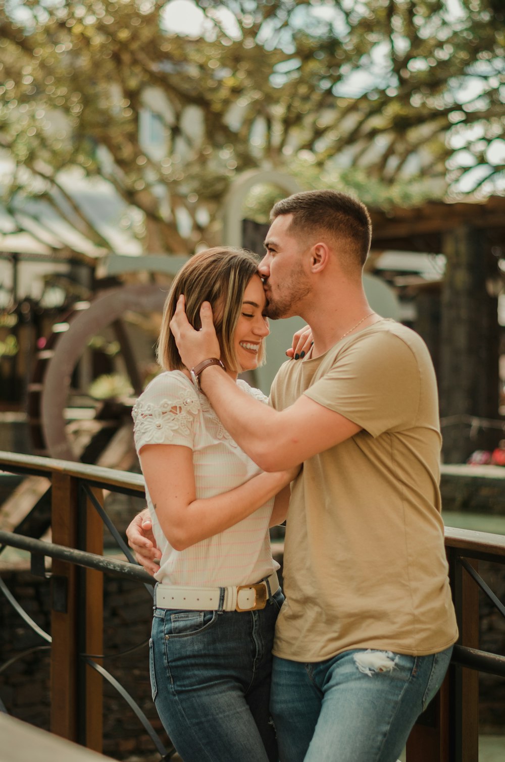 man in yellow shirt kissing woman in white floral dress