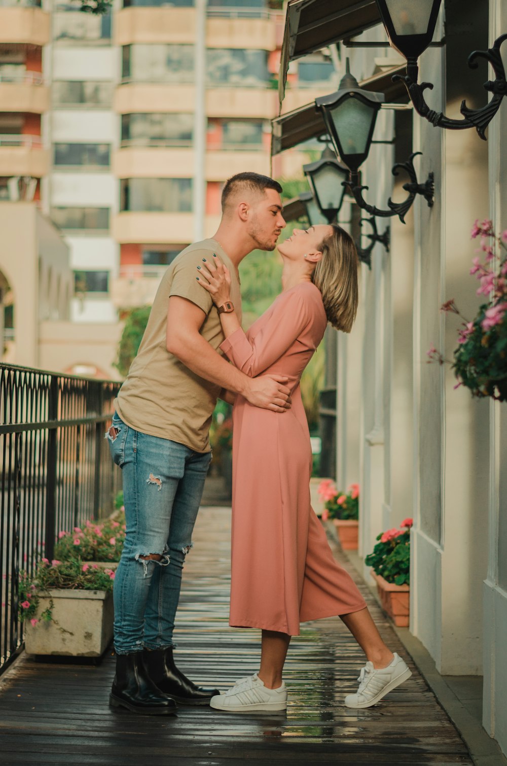 man in brown polo shirt kissing woman in red dress