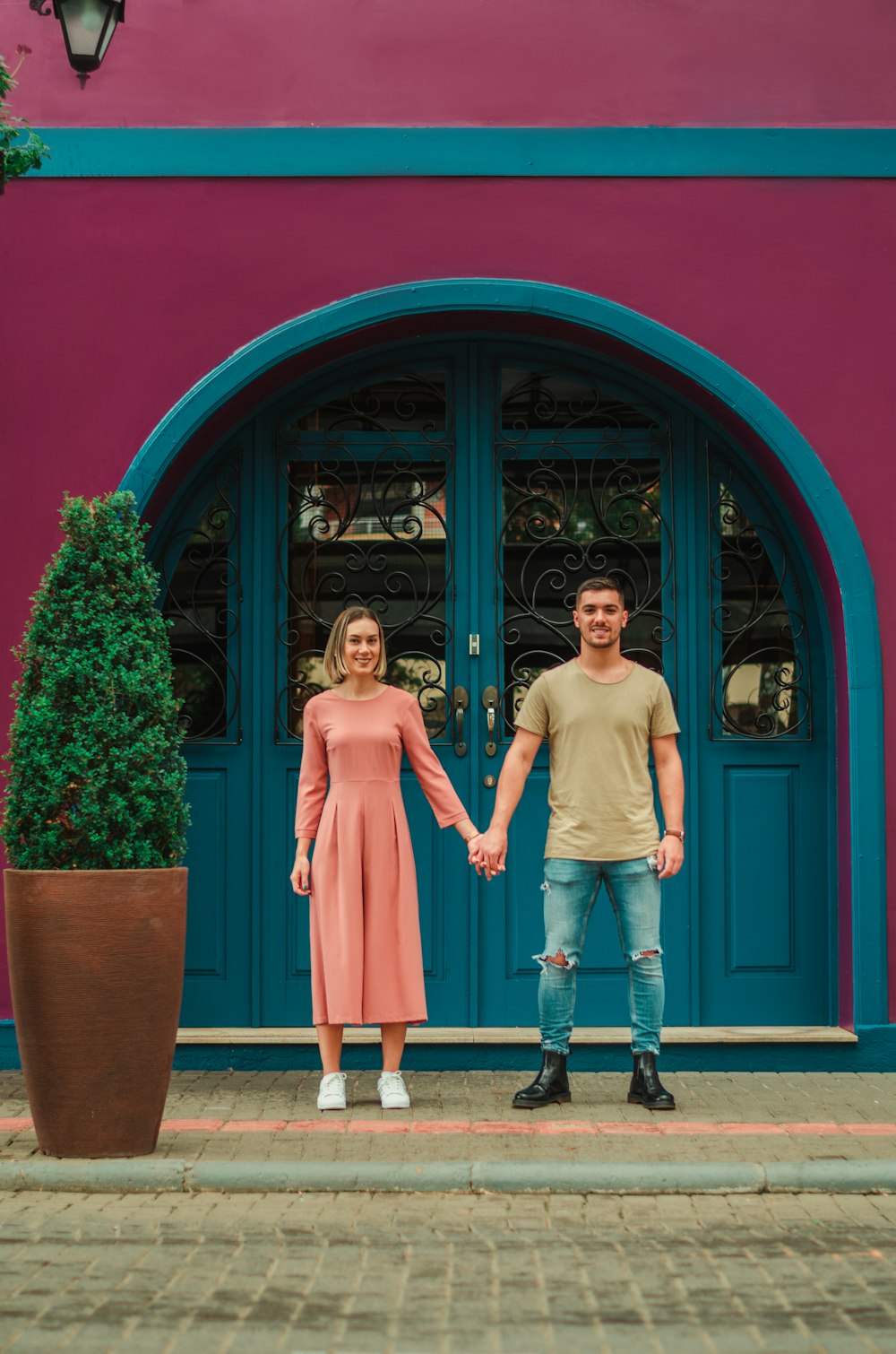 2 women standing beside red wooden door