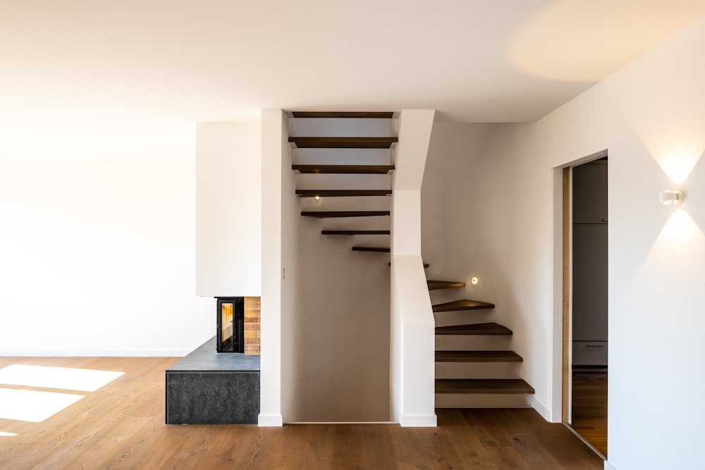 white wooden staircase near white wall