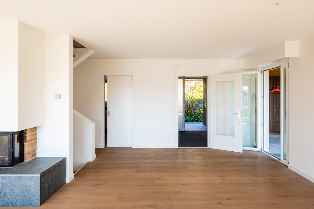Después: habitación terminada con tarima de roble y paredes lisas
