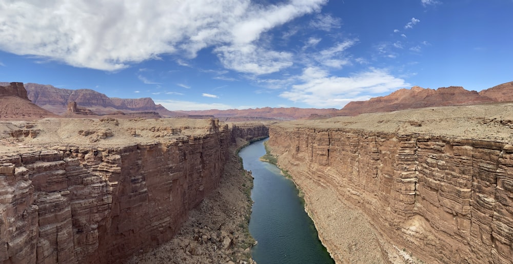 brown rock formation near body of water under blue sky during daytime