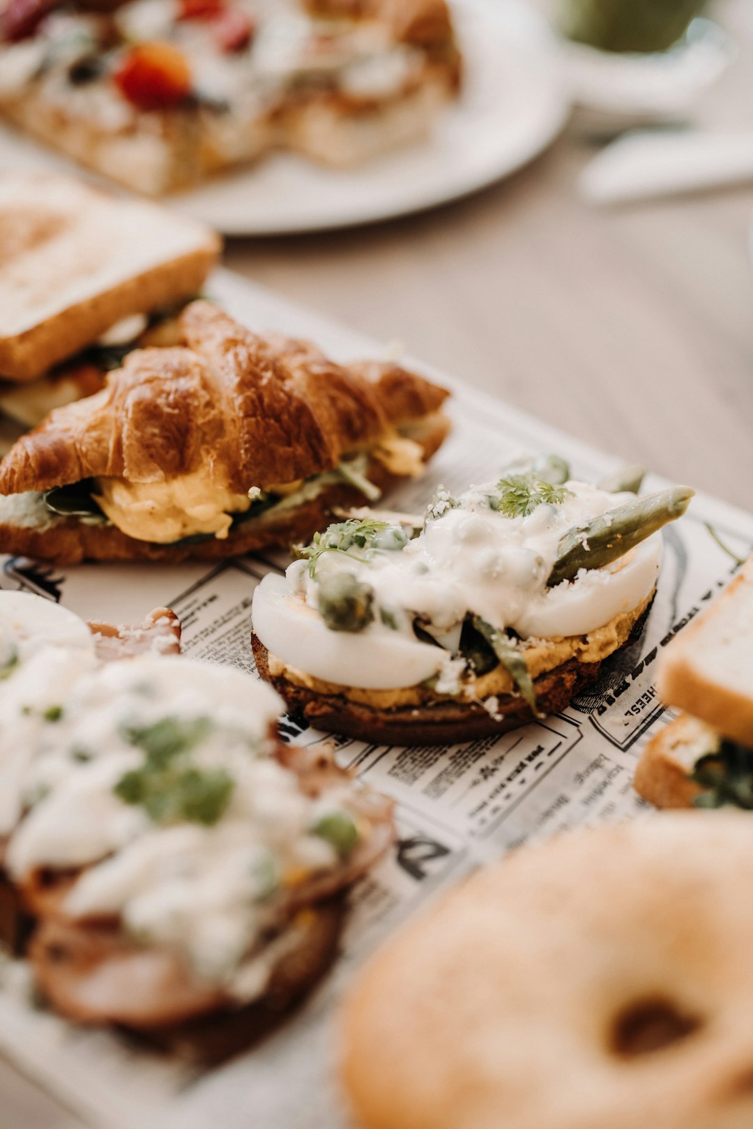 bread with white cream and green vegetable on white ceramic plate