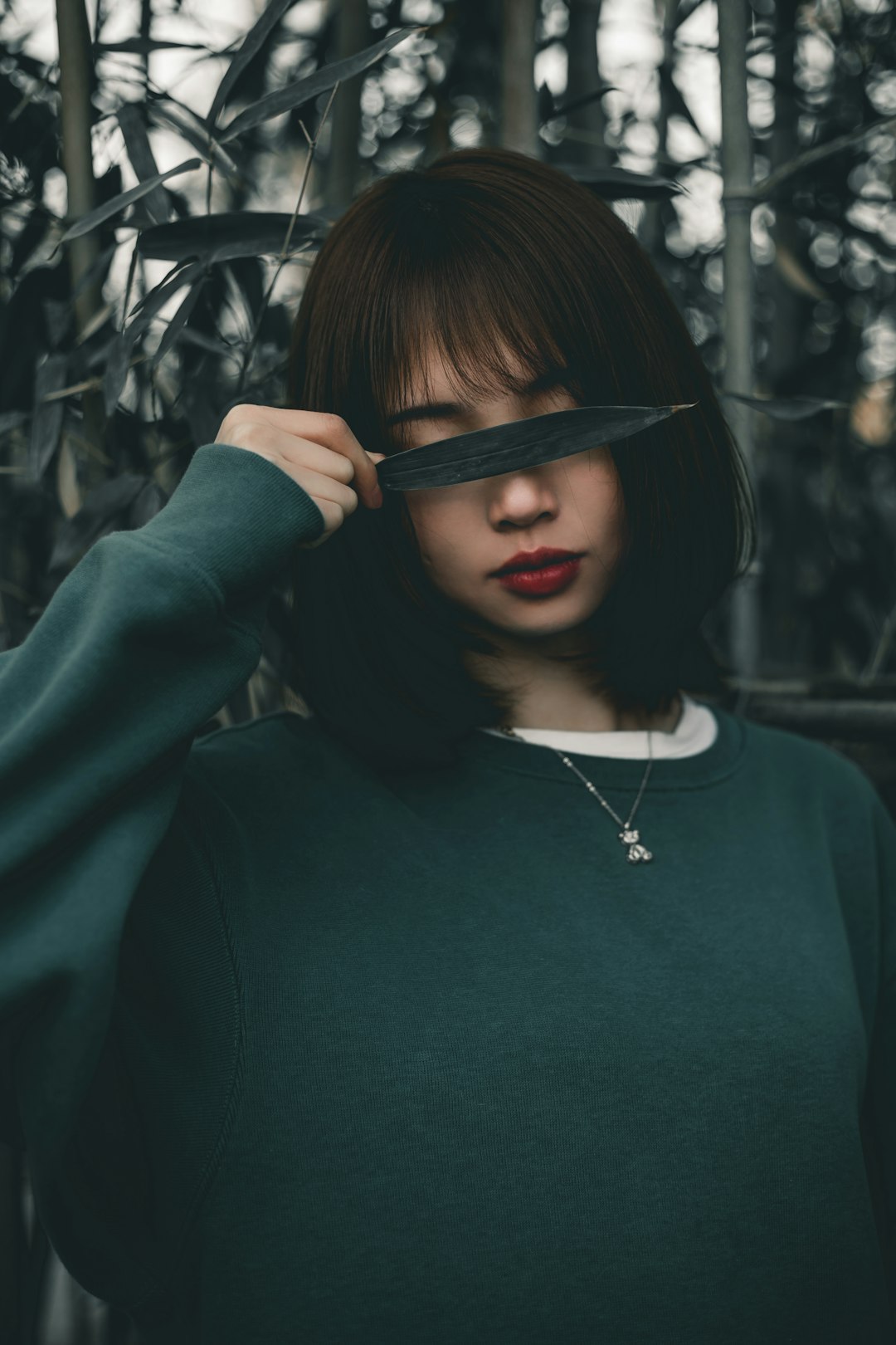 woman in green sweater wearing silver necklace