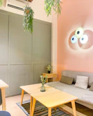 Softly lit living room with warm beige walls, minimalist shelves, and a small potted plant adding a touch of green.