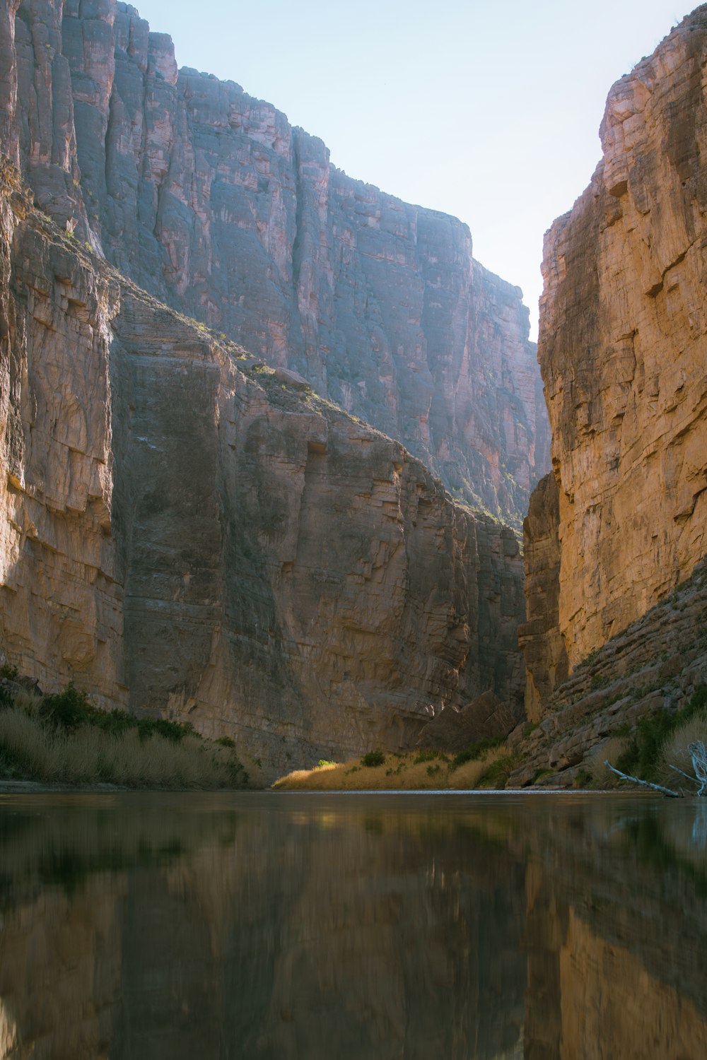 brown rocky mountain beside river during daytime