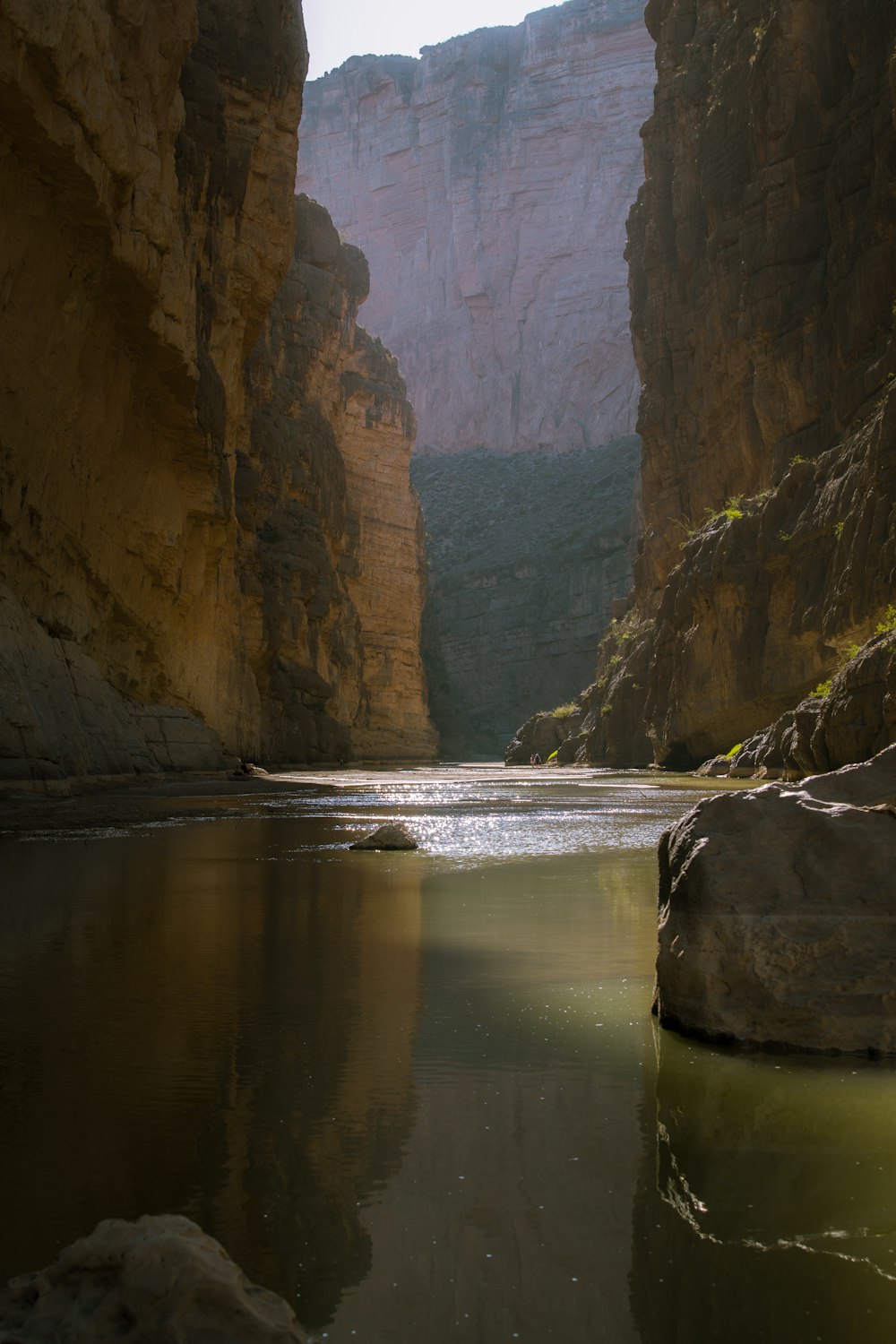 body of water between brown rock formation during daytime