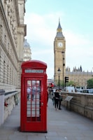 red telephone booth near brown concrete building during daytime