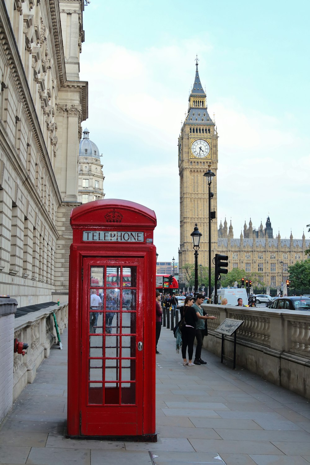 red telephone booth near brown concrete building during daytime