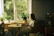 A thoughtful woman reading an empowering ebook while sitting by a window with plants.