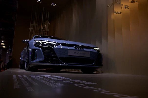 Dynamic angle of a luxury SUV in deep gray with textured background and soft glow effects.