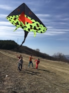 A happy child flying a handmade kite in a sunny park.