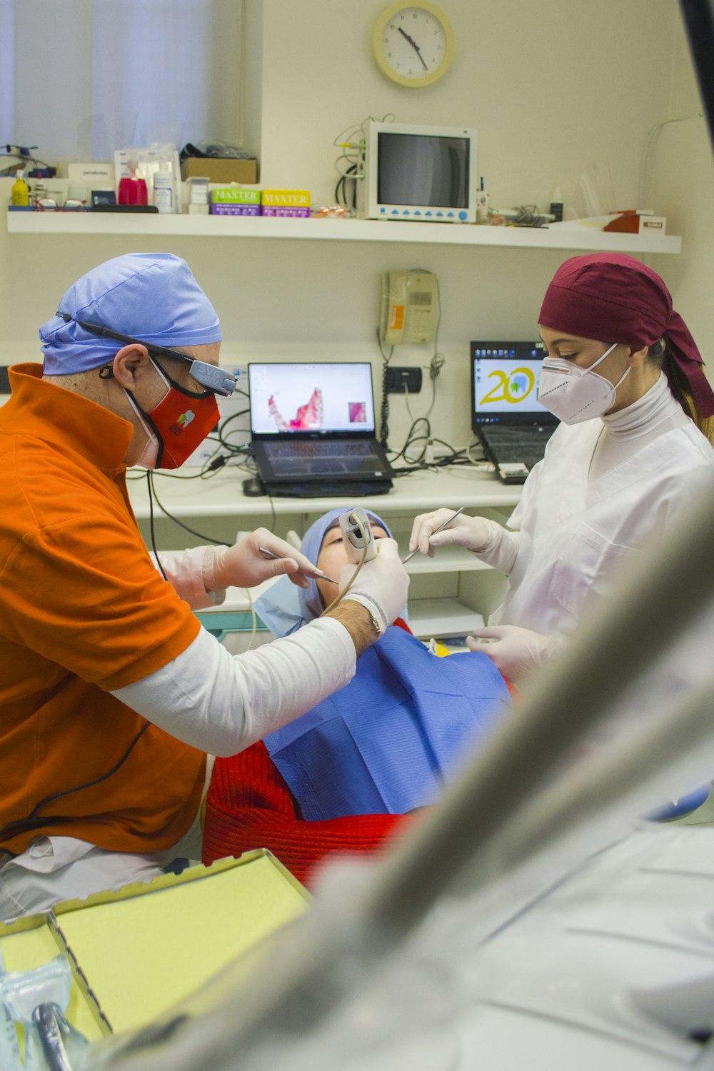 Mujer en traje médico blanco sosteniendo hombre en traje médico azul