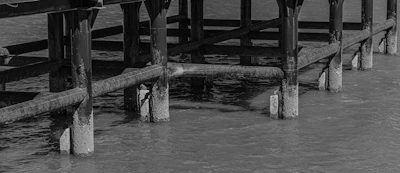 Technician installing crawl space support piers under wooden beams.