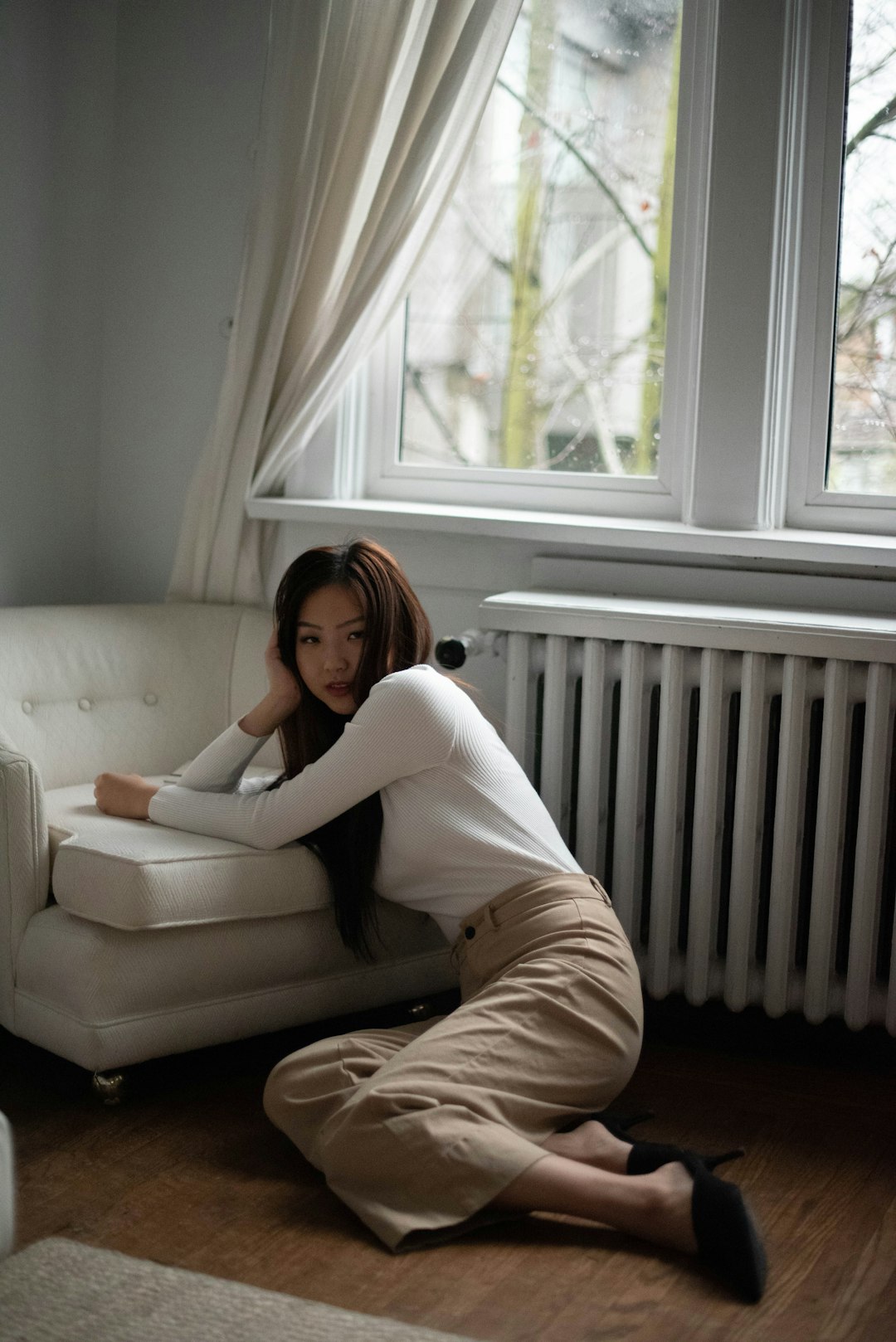 woman in white long sleeve shirt and white pants sitting on white couch