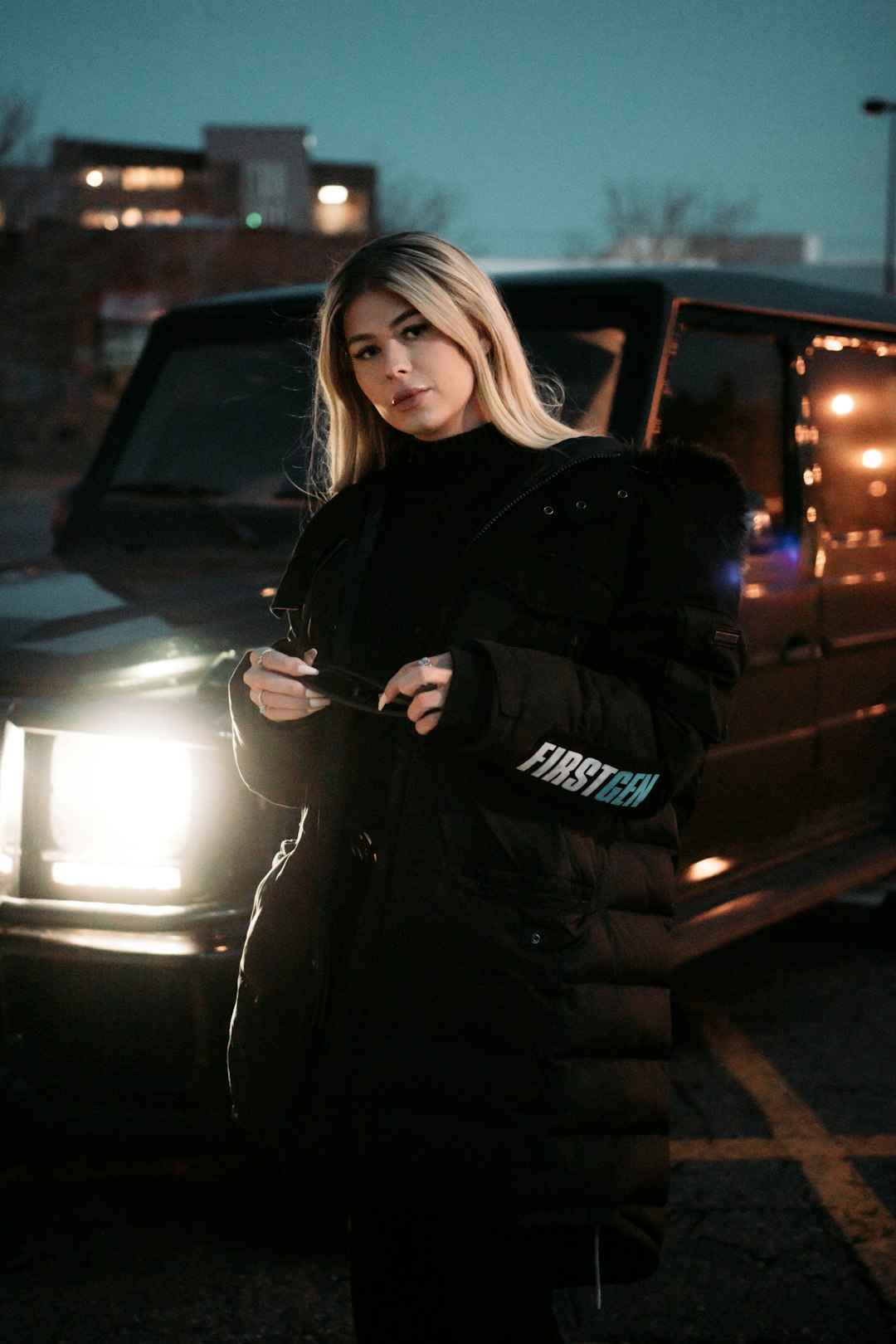 woman in black jacket standing beside black car