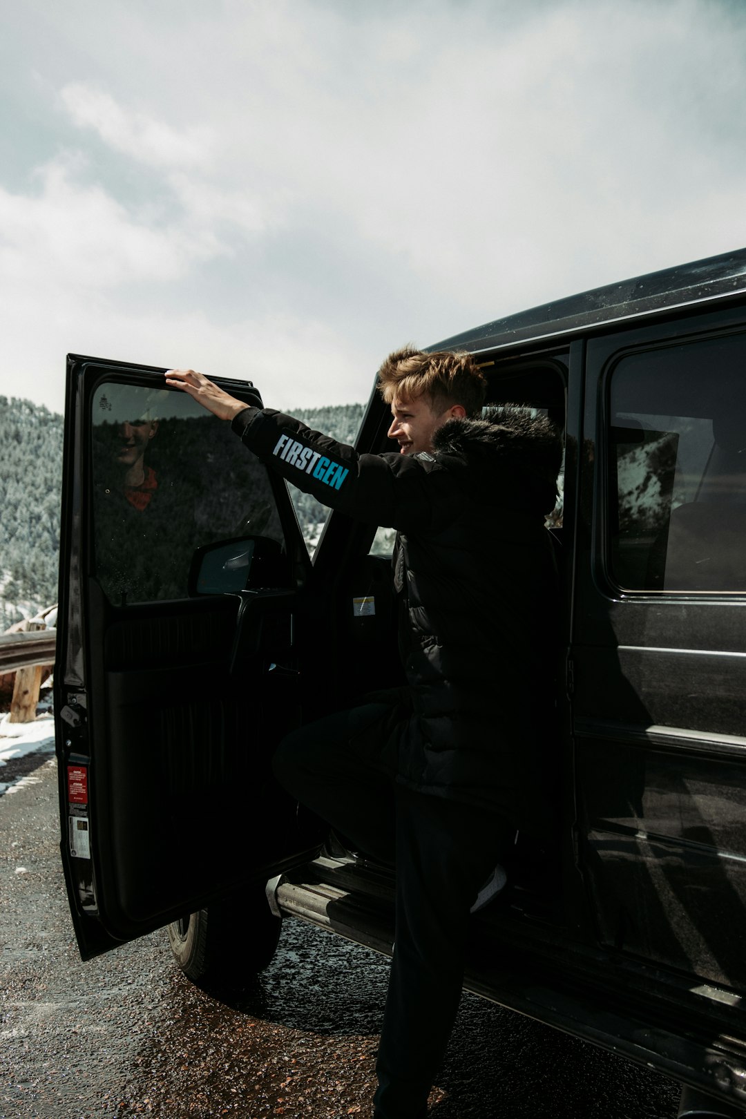 woman in black jacket and pants sitting on black car