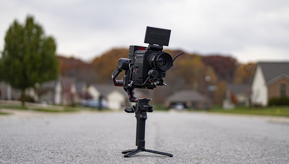 black dslr camera on gray asphalt road during daytime