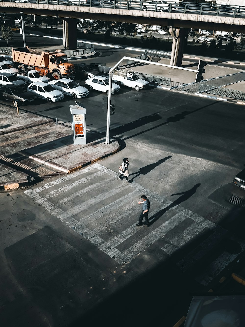 man in black jacket walking on sidewalk during daytime