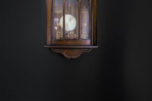 An elegant decorative wall clock with intricate metalwork, ticking softly on a textured wall.