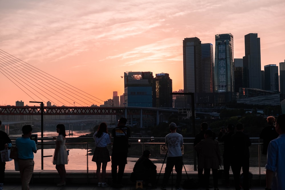 people walking on bridge during sunset