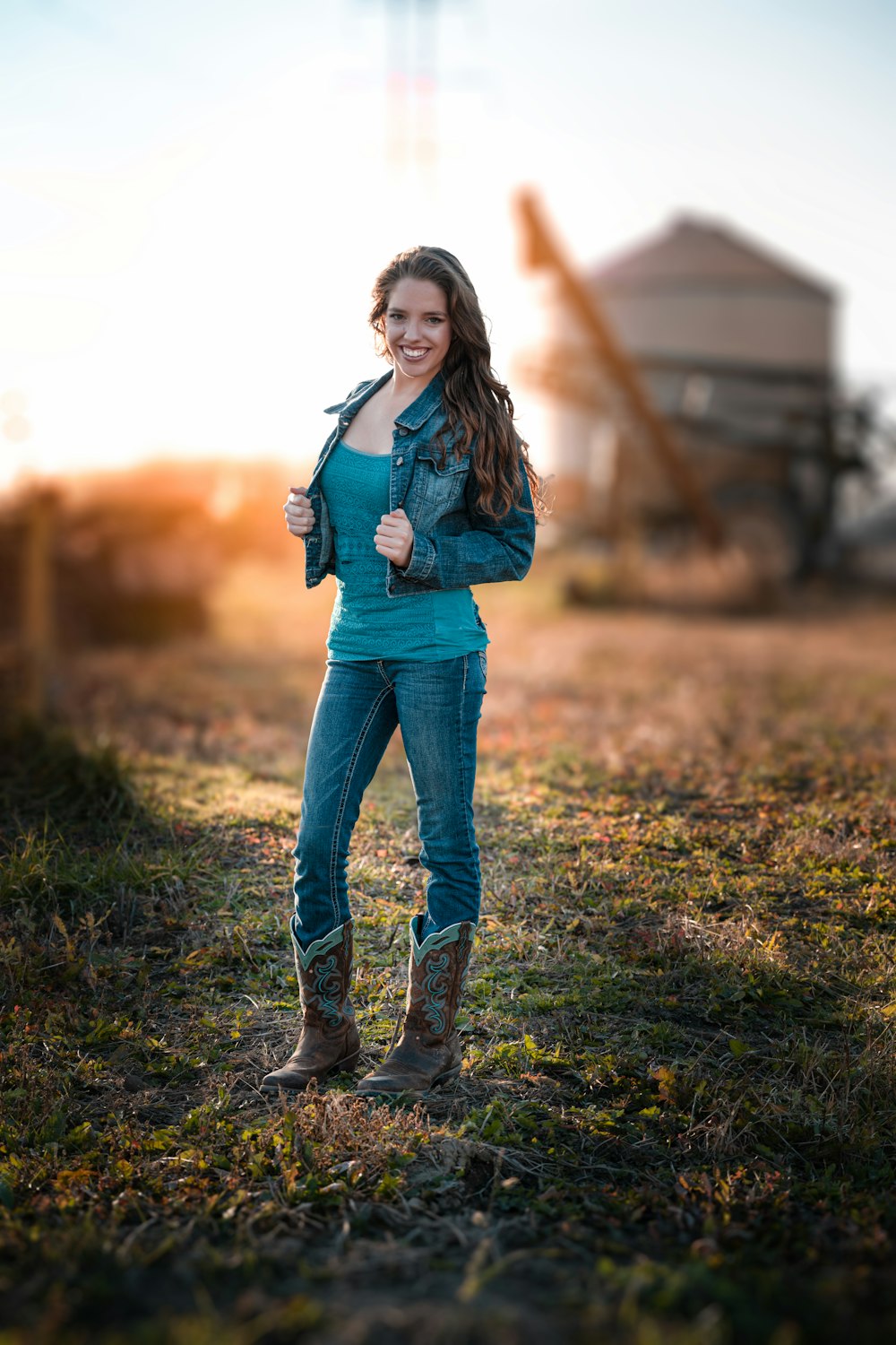 woman in blue denim jeans and black leather boots standing on green grass during daytime