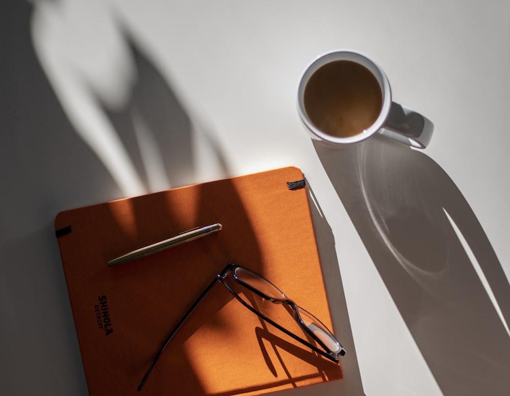 black framed eyeglasses on orange book