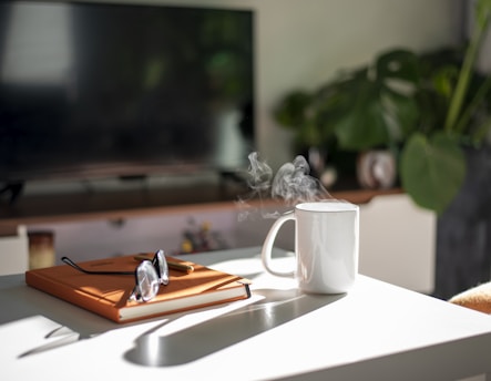 A calm home setting with a hydrogen machine on a table next to a notebook and a cup of tea.