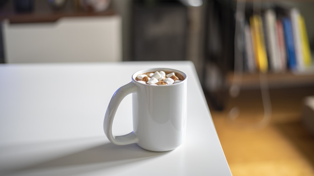 white ceramic mug on white table