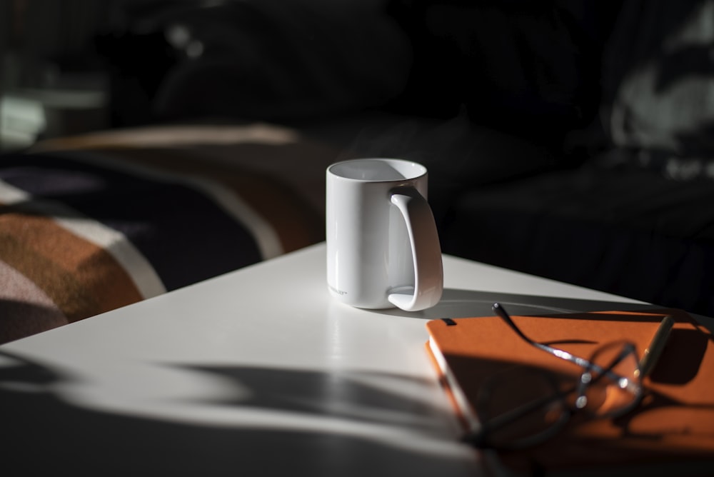 white ceramic mug on white table