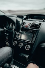 black iphone 4 on car center console