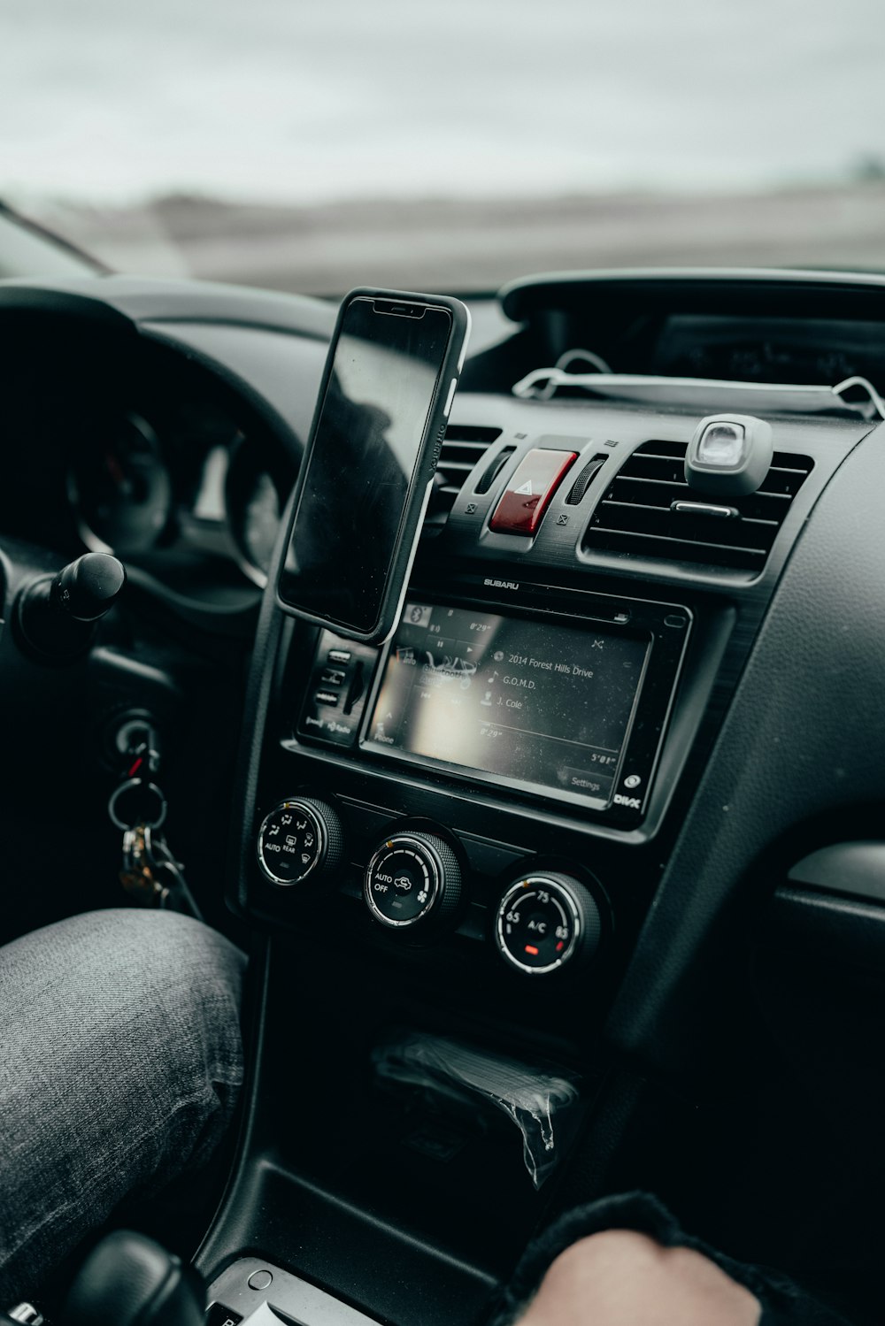 black iphone 4 on car center console