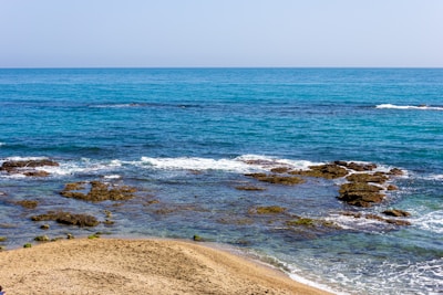 sea waves crashing on shore during daytime