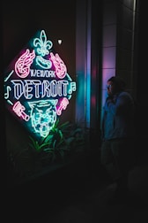 A close-up of a contract being signed with a Detroit skyline visible through the window.