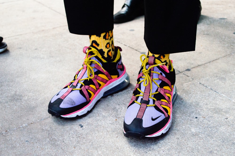 Foto de persona con zapatillas nike negras, azules y amarillas – Imagen  gratuita Moda en Unsplash