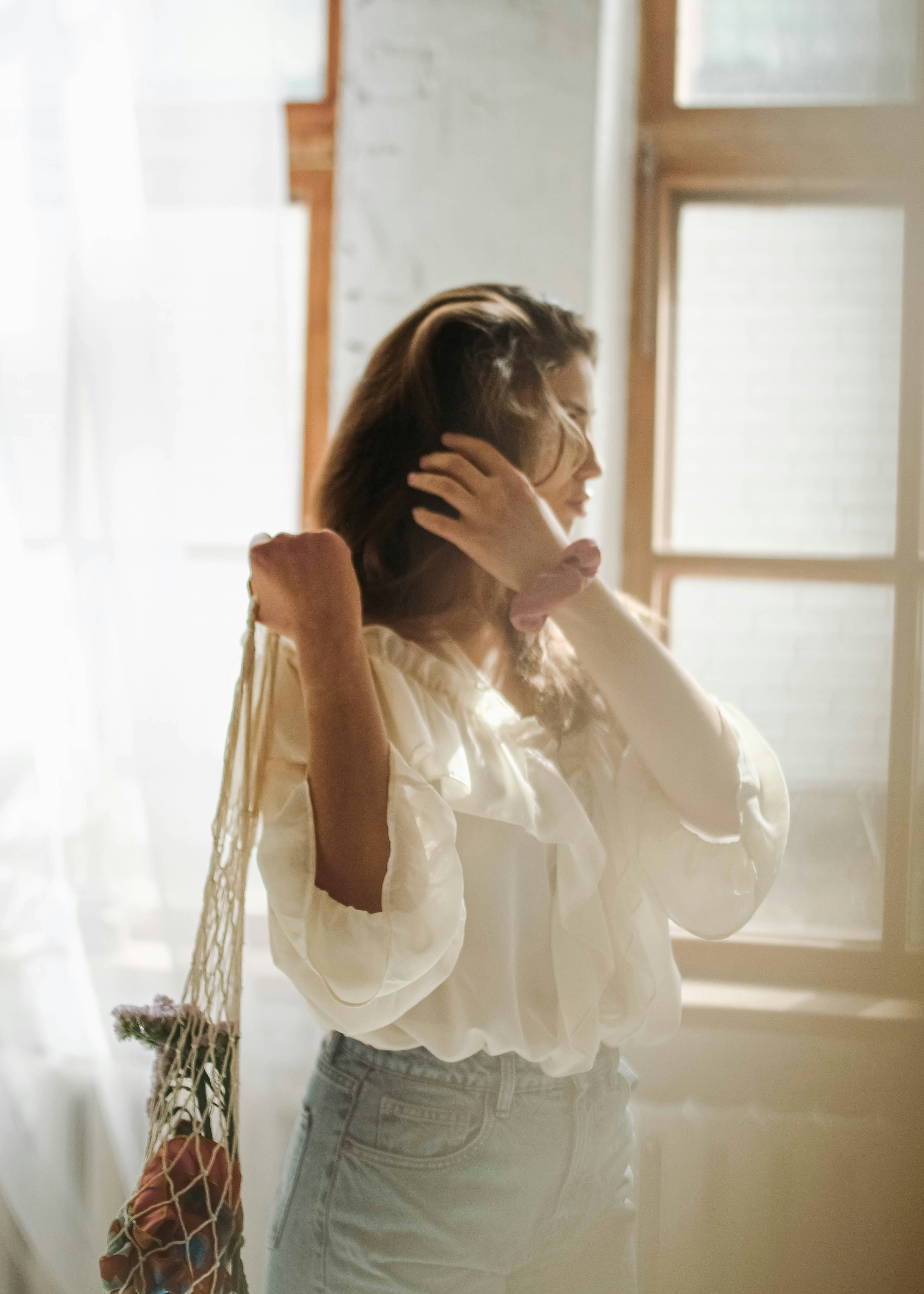 woman in white dress covering her face with her hair