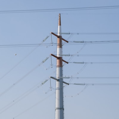 white and red electric post under white sky during daytime