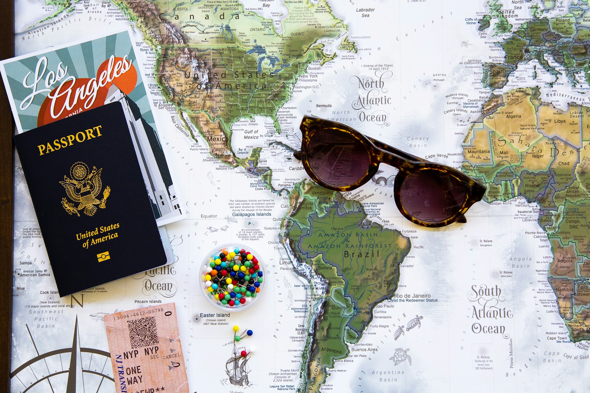 cartina geografica, occhiali da sole e passaporto americano