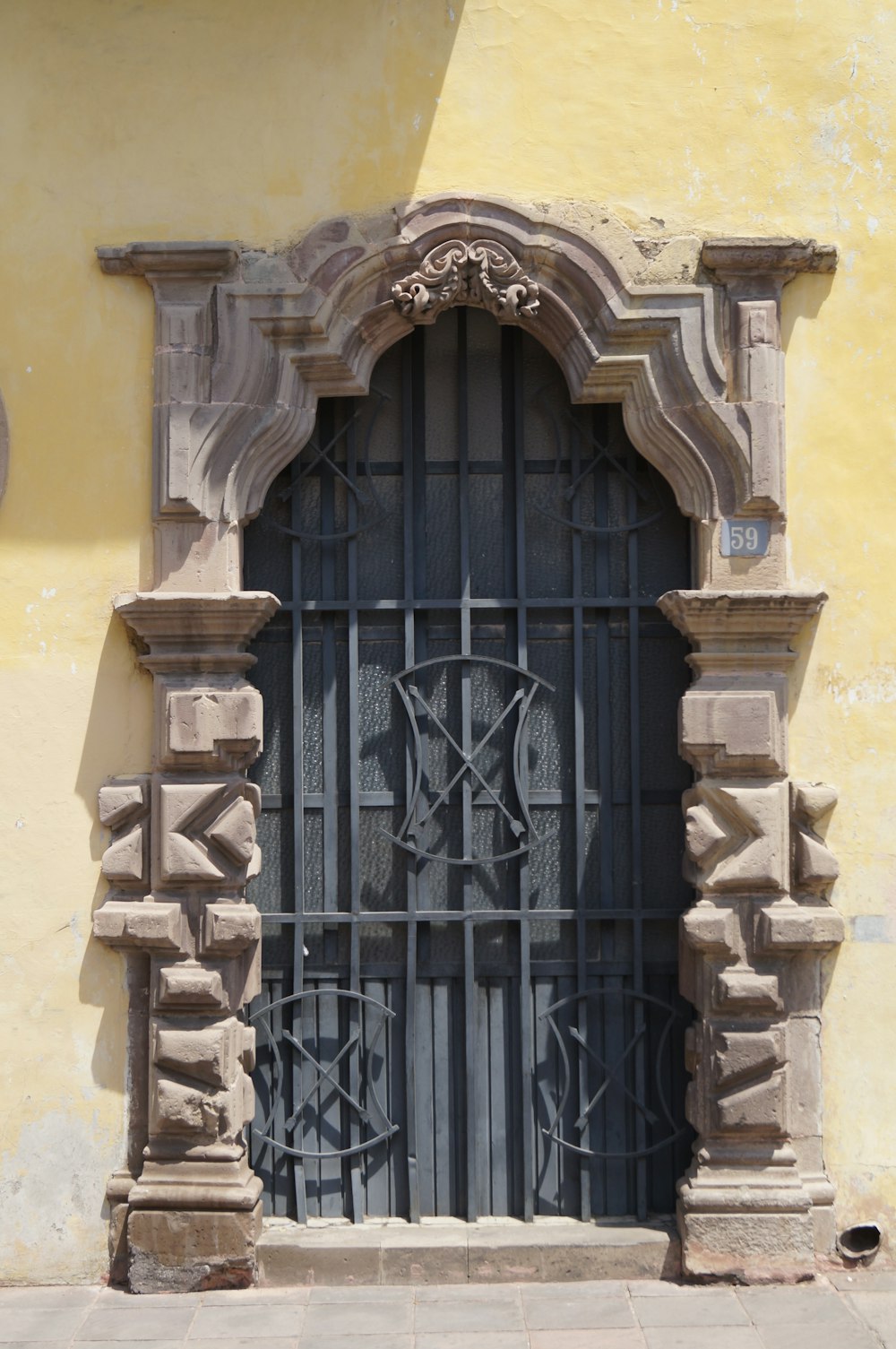 black metal gate on yellow concrete building