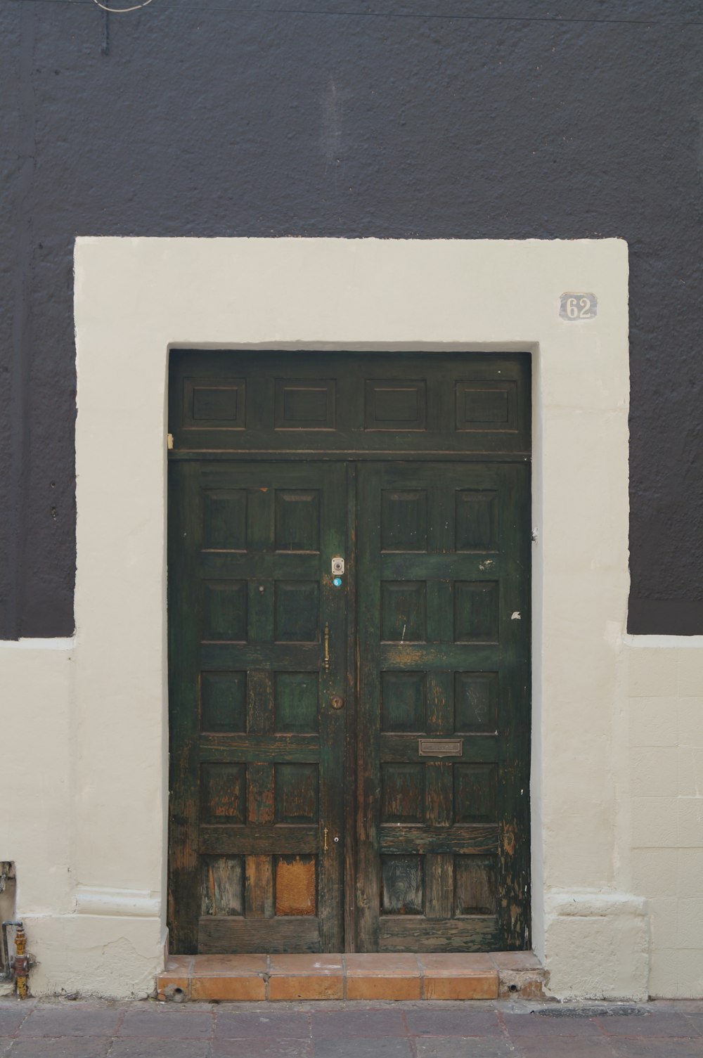 black wooden door on white concrete wall